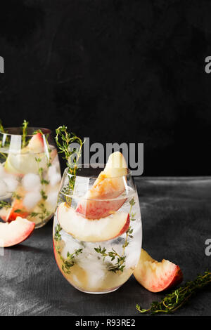 Pesche nettarine limonata a freddo con il timo ingredienti diversi due bicchieri su sfondo scuro Foto Stock
