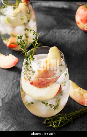 Pesche nettarine limonata a freddo con il timo ingredienti diversi due bicchieri su sfondo scuro Foto Stock