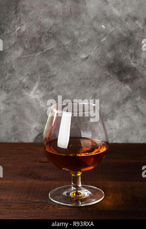 Cognac in vetro su sfondo di legno Foto Stock