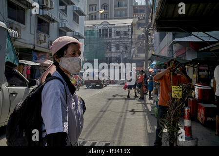 Donna che indossa un maschera antinquinamento per proteggere contro lo smog in una strada tailandese. Pattaya Sud-est asiatico Foto Stock