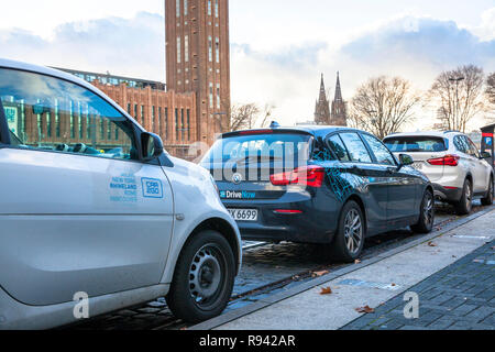 Vetture del carsharing aziende unità ora e Auto2Go nel quartiere Deutz di Colonia, Germania. Fahrzeuge der carsharing Unternehmen unità ora und auto Foto Stock