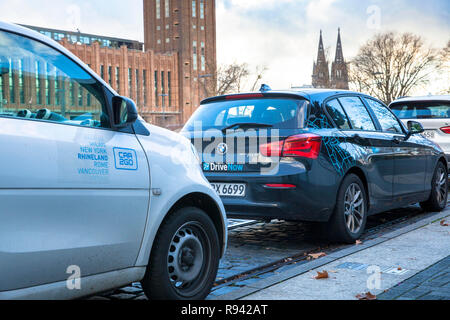 Vetture del carsharing aziende unità ora e Auto2Go nel quartiere Deutz di Colonia, Germania. Fahrzeuge der carsharing Unternehmen unità ora und auto Foto Stock