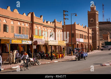 Il Marocco, Agdz, centro città, negozi locali accanto al minareto della moschea Foto Stock