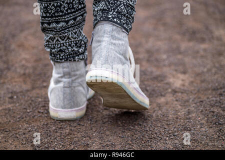 In prossimità di un paio di scarpe. Ragazze piedi sneakers bianco. Foto Stock
