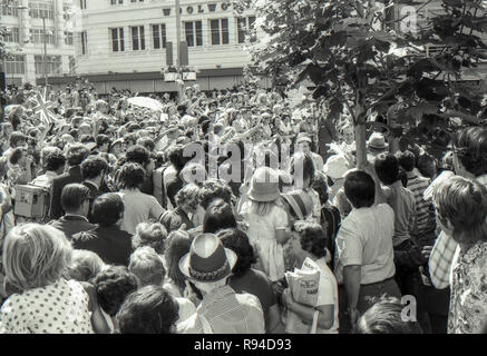 Sydney Australia, 13 marzo 1977: una folla di persone di tutte le età la linea delle barricate e wave e allegria presso l arrivo della Regina Elisabetta II e del Principe Filippo a Sydney piazza vicino al Municipio. La coppia reale ha partecipato ad un ricevimento civico con il sindaco, Leo porto e poi un servizio presso la vicina St Andrews Cattedrale. Sua Maestà la Regina e il principe sono stati in visita a Sydney insieme a numerose altre parti dell'Australia durante il mese di marzo come parte del loro Giubileo d'argento world tour. Credito foto Stephen Dwyer (Età 17) Foto Stock