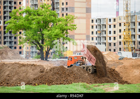 Autocarro con pianale di scarico scarica il terreno. Sito in costruzione. Foto Stock