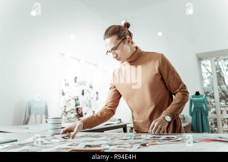 Alto giovani designer bello in occhiali cercando focalizzata Foto Stock