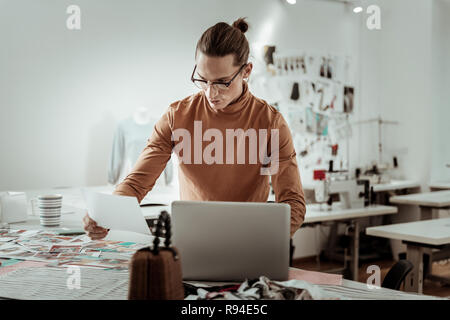 Bello da designer di moda di studio al lavoro su un notebook Foto Stock