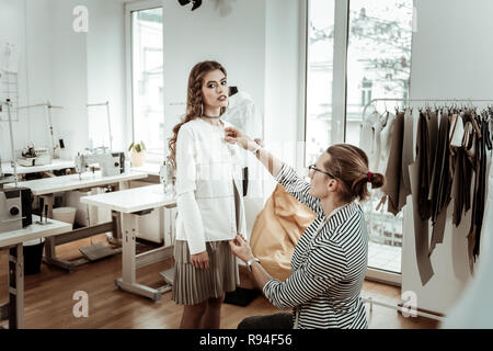 Trasmissione via IR di incredibile ragazza dai capelli scuri in un mantello beige sentimento buono Foto Stock