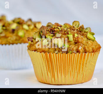 Banana Muffin arancione con schiacciato pistacchi topping Foto Stock