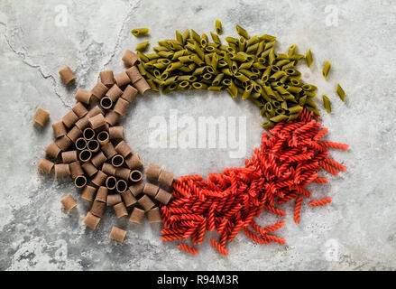 Multicolor pasta aglutinica con ingredienti da cui essa è fatta su un tavolo di pietra Foto Stock