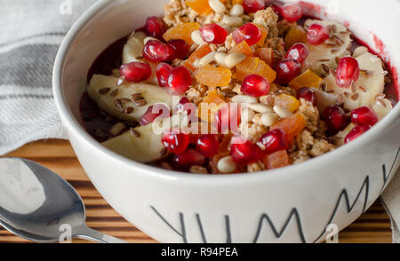 Acai Smoothie ciotola e rabboccato con melograno, banane, flaxseeds, semi di cedro, albicocca secca e granola. Acai colazione frullato superfoods ciotola e sp Foto Stock