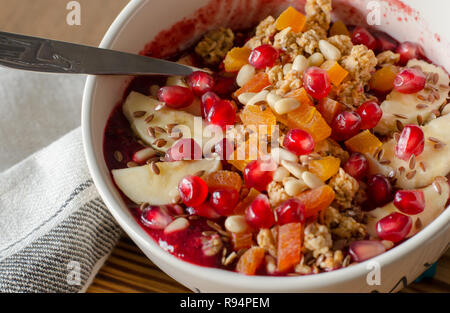 Acai Smoothie ciotola e rabboccato con melograno, banane, flaxseeds, semi di cedro, albicocca secca e granola. Acai colazione frullato superfoods ciotola e sp Foto Stock