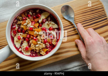 Acai Smoothie ciotola e rabboccato con melograno, banane, flaxseeds, semi di cedro, albicocca secca e granola. Acai colazione frullato superfoods ciotola e ha Foto Stock