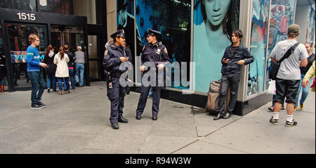 New York, Stati Uniti d'America - 13 Novembre 2008: due americani femminile o le belle donne, gli agenti di polizia, in uniformi di pattugliamento per via della città di giorno sul paesaggio urbano in background. Pubblica sicurezza Foto Stock