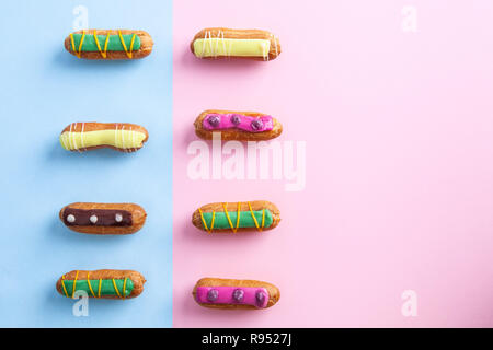 Due righe di decorato in maniera colorata eclairs con spazio di copia Foto Stock