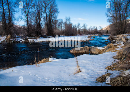 Nevoso inverno prati e piccolo ruscello. Foto Stock