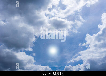 Bianchi e soffici nuvole e sole sul davanti del cielo blu. Foto Stock