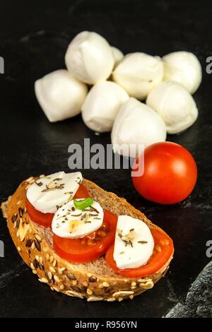 Mozzarella e pomodoro sulla piastra di ardesia. La dieta alimentare. La preparazione del cibo. Vendita di formaggi. Protein diet. Foto Stock