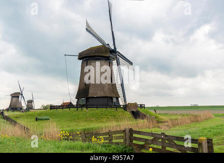 Il Museo di Schermerhorn mulino in una fila di tre mulini a vento su un blustery giorno nuvoloso a Schermerhorn, North Holland, Paesi Bassi Foto Stock