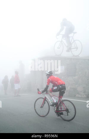 I turisti a guardare la statua per il Tour de France ciclista Octave Lapize al Col du Tourmalet nella fitta nebbia nei Pirenei, Francia Foto Stock