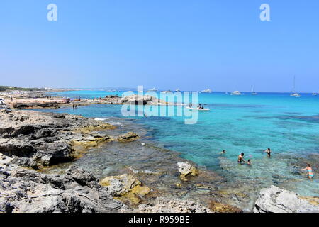 Barche ancorate e persone a giocare in mare, Es Calo, Formentera, Spagna Foto Stock