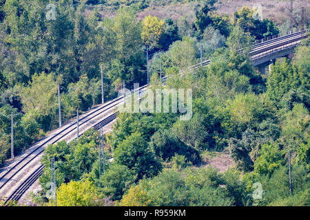 Doppia diagonale di binari ferroviari che attraversa un bosco, elevato angolo vista da sopra nei pressi della stazione ferroviaria di Karlukovo, nel nord della Bulgaria in una soleggiata autunno Foto Stock