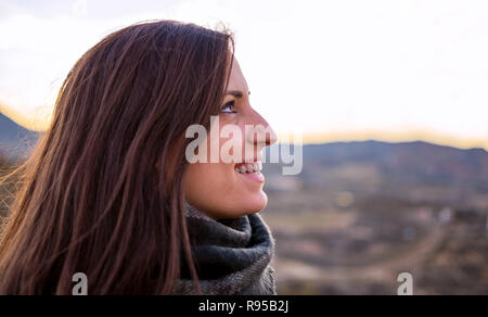 Donna sorridente ritratto vista laterale. Giovani caucasici ragazza spagnola contro i campi di agricoltura. Libertà nella natura. Foto Stock