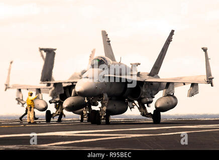Un ponte di volo guide direttore un F/A-18C Hornet attaccato al Argonauts di Strike Fighter Squadron uno quattro sette (VFA- 147) sul ponte di volo dell'Nimitz-class portaerei USS John C. Stennis (CVN 74). Stati Uniti Foto di Marina di Massa lo specialista di comunicazione di terza classe Jon Hyde Foto Stock