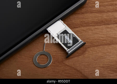 Scheda SIM e la scheda microSD vassoio con lo strumento di rimozione sul lato dello smartphone Foto Stock