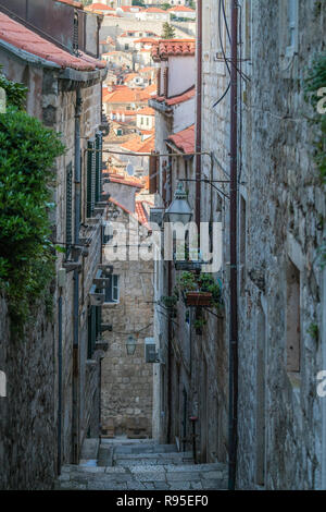 Passi per la ripida stradina di passaggio tra gli edifici residenziali nel paese vecchio di Dubrovnik, Croazia Foto Stock