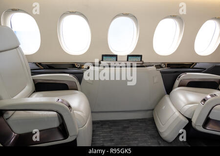 Cabina Comfortible sedie in un moderno business jet aerei durante il volo. Foto Stock