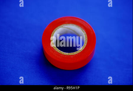 Rosso nastro isolante su sfondo blu Foto Stock