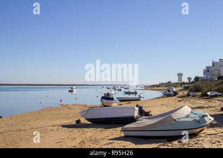 Faro, Portogallo. Una vista della spiaggia sul lato Laguna di Ria Formosa dell'Isola di Faro con piccole barche legate e ormeggiate nella laguna stessa. Foto Stock