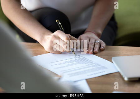 Mano femmina penna a sfera di attesa dopo il controllo paper ready firmarlo Foto Stock
