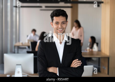 Medio Oriente imprenditore di etnia in tuta in posa di coworking Foto Stock