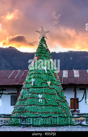 San Juan la Laguna, lago Atitlan, Guatemala - Dicembre 16, 2018: albero di Natale artificiale contro il cielo al tramonto in riva al lago di San Juan la Laguna. Foto Stock