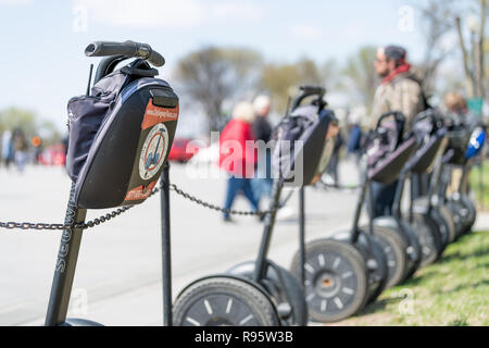 Washington DC, Stati Uniti d'America - Aprile 5, 2018: City Tours segway segways parcheggiato, lasciato a piedi al parco con nessuno, gente che passeggia in background sul mal nazionale Foto Stock