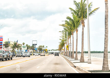 Key West, Stati Uniti d'America - 1 Maggio 2018: Righe, fila di molte palme sul boulevard con molte vetture, cartelli stradali in Florida keys urban isola sulla Overseas Highway Foto Stock