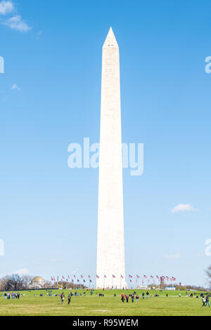 Washington DC, Stati Uniti d'America - Aprile 5, 2018: il Monumento a Washington con bandierine americane nel cerchio, persone turisti isolata contro il cielo blu sul National Mall wit Foto Stock