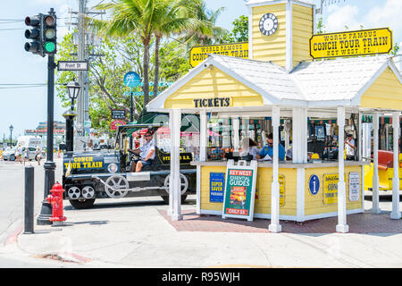 Key West, Stati Uniti d'America - 1 Maggio 2018: Persone a cavallo di colore giallo tour bus carrello con i turisti alla strada in Florida isola su viaggi, giornata soleggiata, Conch Tr Foto Stock