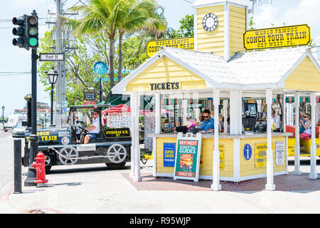 Key West, Stati Uniti d'America - 1 Maggio 2018: persone, i turisti a cavallo di colore giallo tour bus carrello alla strada in Florida isola su viaggi, giornata soleggiata, Conch Train Foto Stock