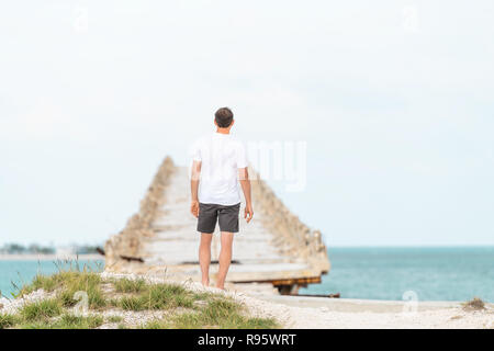 Giovane uomo in piedi nella parte anteriore del vecchio Seven Mile Bridge, Cavalieri Key-Pigeon Key-Moser Channel-Pacet canale, turisti in vacanza, orizzonte seascape in Bah Foto Stock