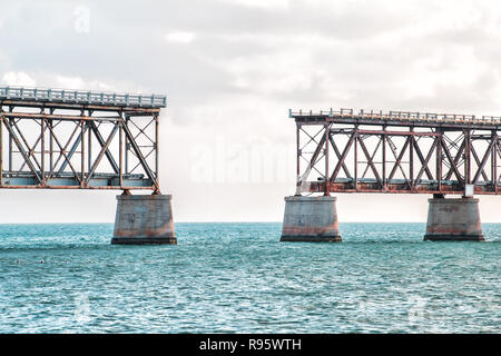 Vecchio arrugginito, ruggine, rusty derelitti Bahia Honda rail road nel parco dello stato, nubi nuvoloso cielo blu al tramonto, crepuscolo, Horizon, oceano, acqua di mare Foto Stock