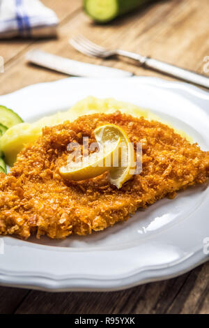 Chicken fried schnitzel con purè di patate e limone sul tavolo di legno Foto Stock