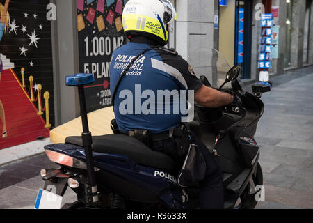 In questa foto un poliziotto in sovrappeso che indossa la sua uniforme è visto in sella ad una bicicletta. Egli è visto indossare un casco e un bastone attaccato al suo retro. Sul Foto Stock