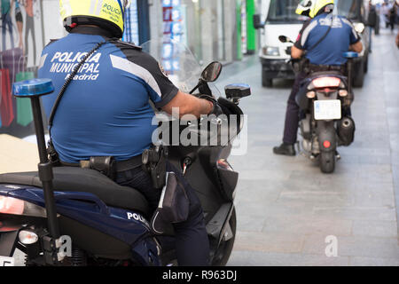 In questa foto un poliziotto in sovrappeso che indossa la sua uniforme è visto in sella ad una bicicletta. Egli è visto indossare un casco e un bastone attaccato al suo retro. Sul Foto Stock