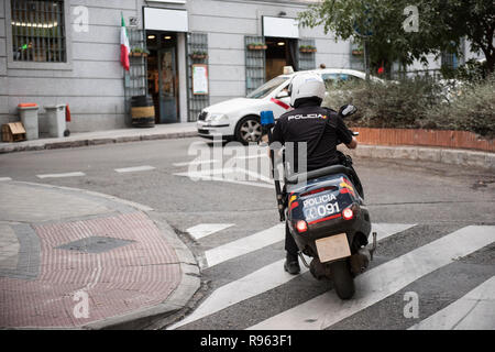 In questa foto un poliziotto che indossa la sua uniforme è visto in sella ad una bicicletta. Egli è visto indossare un casco e un bastone attaccato al suo retro. Sullo sfondo, Foto Stock