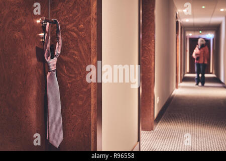 Tirante appesi ad un hotel chiuso maniglia della porta, non disturbare segno informale, retro colorati, applicato il fuoco selettivo. Foto Stock