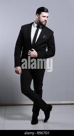 Corpo pieno ritratto di bello business man in posa eretta gambe incrociate Foto Stock
